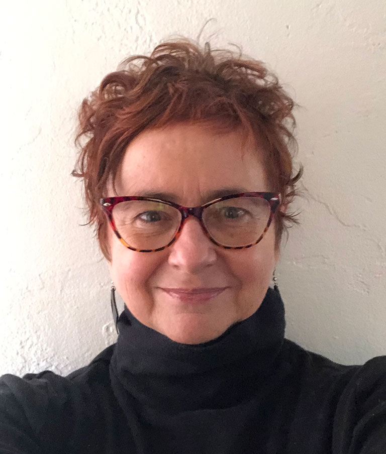 A headshot of graduate student Rowena Galavitz, who wears a black turtleneck sweater and glasses.